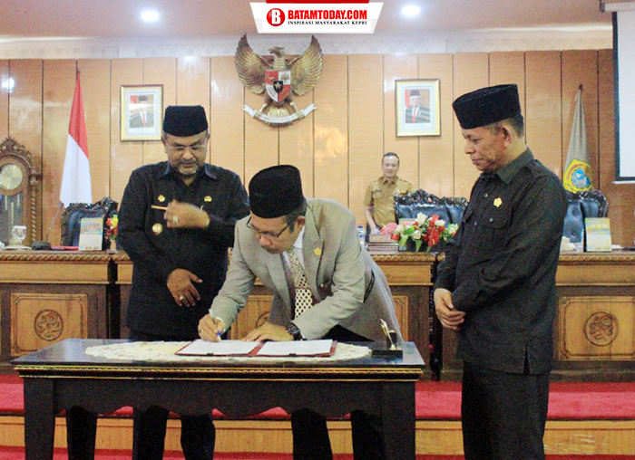 Ketua DPRD Karimun, Muhammad Yusuf Sirat saat menandatangani berita acara hasil paripurna disaksikan Bupati dan Wakil Ketua DPRD,Rasno 